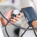 پزشک در حال اندازه گیری فشار خون بیمار