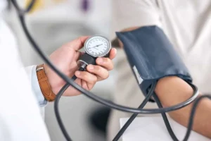 پزشک در حال اندازه گیری فشار خون بیمار