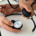 پزشک در حال اندازه گیری فشار خون بیمار