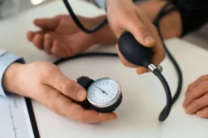 پزشک در حال اندازه گیری فشار خون بیمار