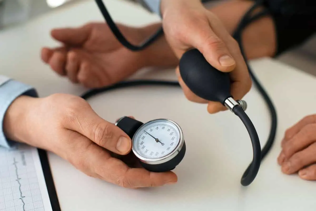 پزشک در حال اندازه گیری فشار خون بیمار