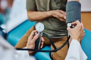پزشک در حال اندازه گیری فشار خون یک مرد
