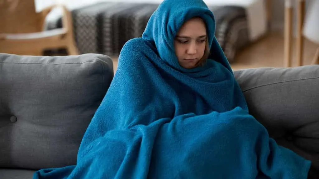 زنی که از شدت سرما پتو به خود پیچیده