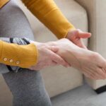 یک زن در حال بررسی کف پای خود است