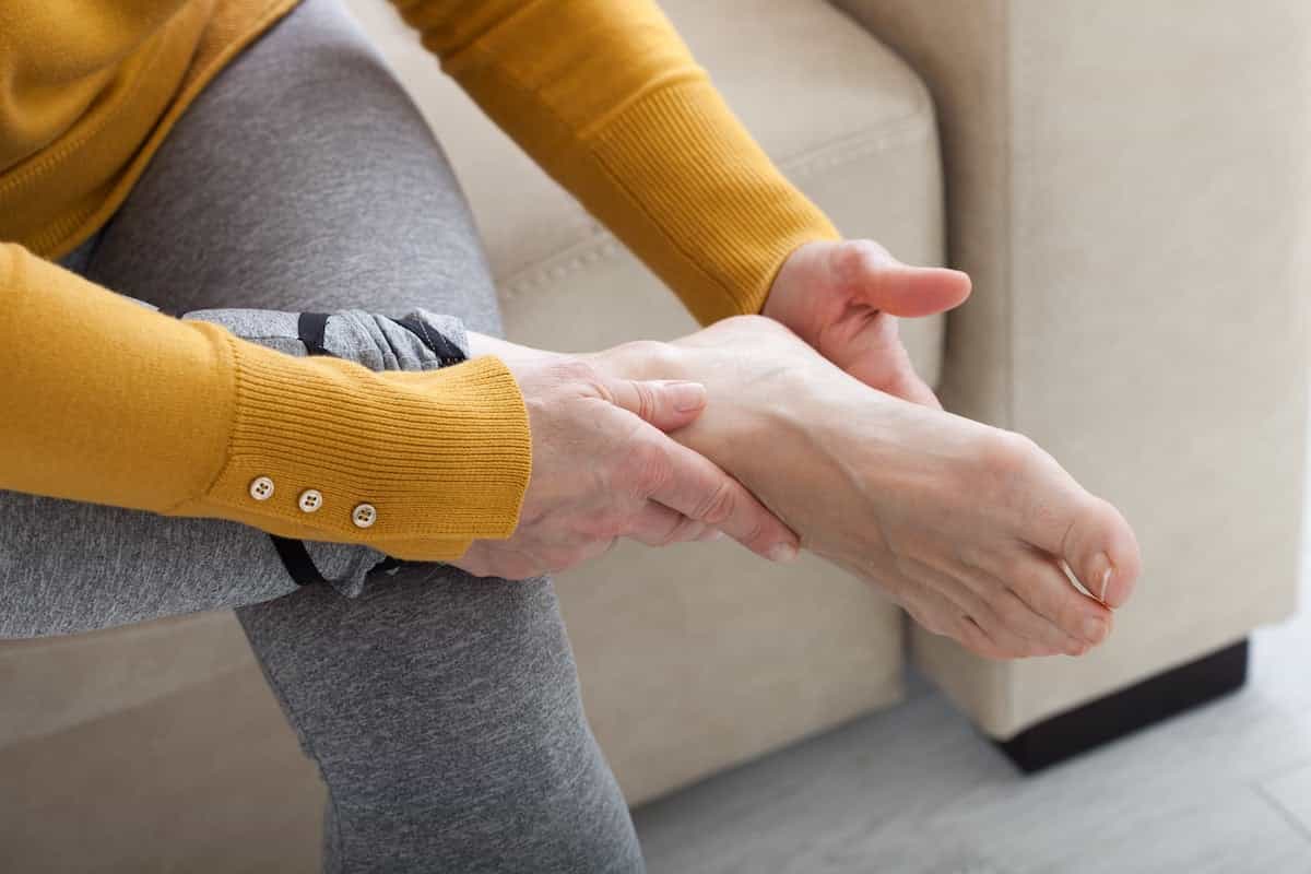 یک زن در حال بررسی کف پای خود است