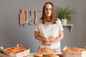 زن جوان دستش را روی شکمش گذاشته