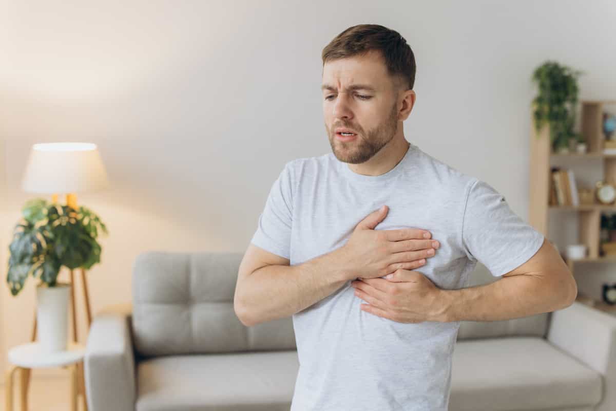 مرد جوان دست هایش را روی قلب خود گذاشته است