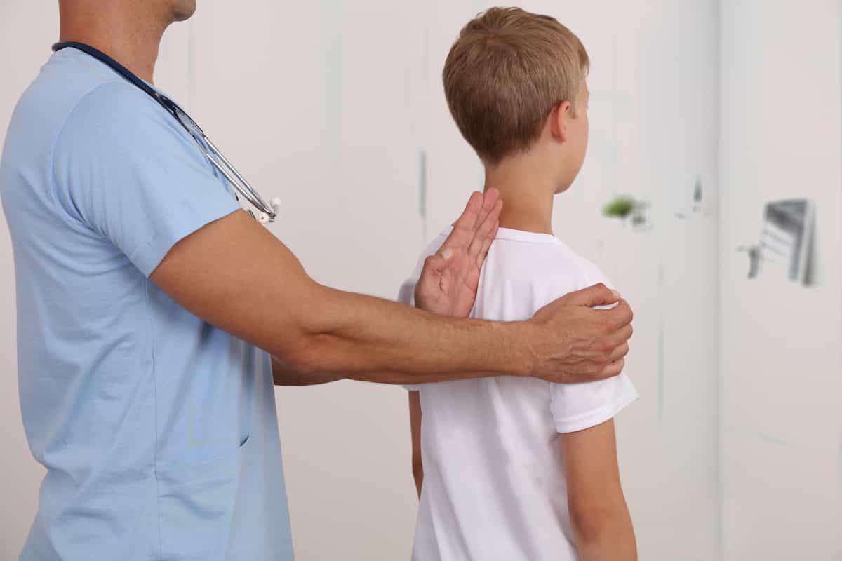 پزشک در حال معاینه قوز پشت کودک
