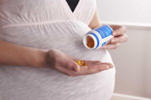 زن باردار در حال خوردن قرص مکمل