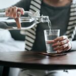شخص در حال ریختن آب در لیوان
