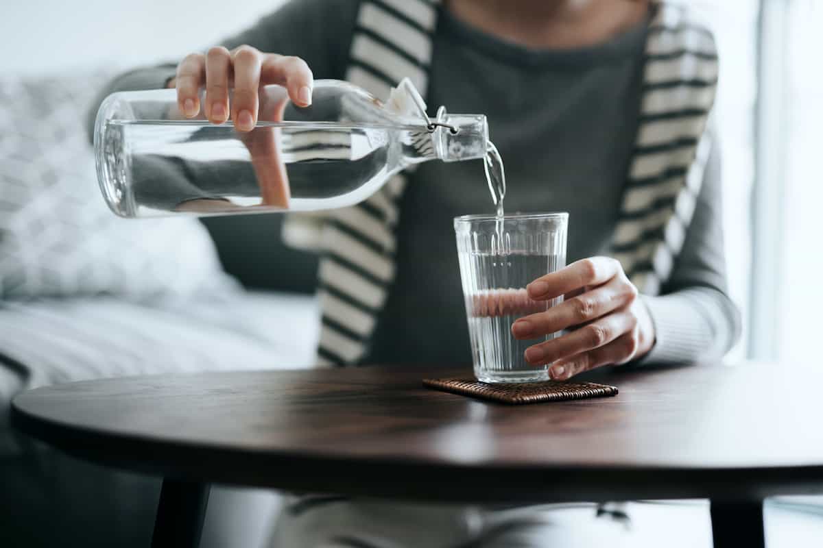 شخص در حال ریختن آب در لیوان